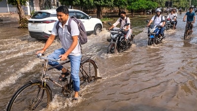 Commuters wade through a waterlogged road following heavy rain, in Gurugram, Haryana, Saturday, Aug. 22, 2026. (PTI)