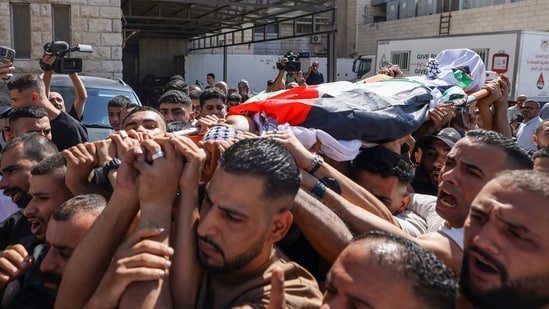 Mourners carry the body of Palestinian Islam Ajouri, 14, at Rafidia Hospital in Nablus in the Israeli-occupied West Bank, on August 23, 2026