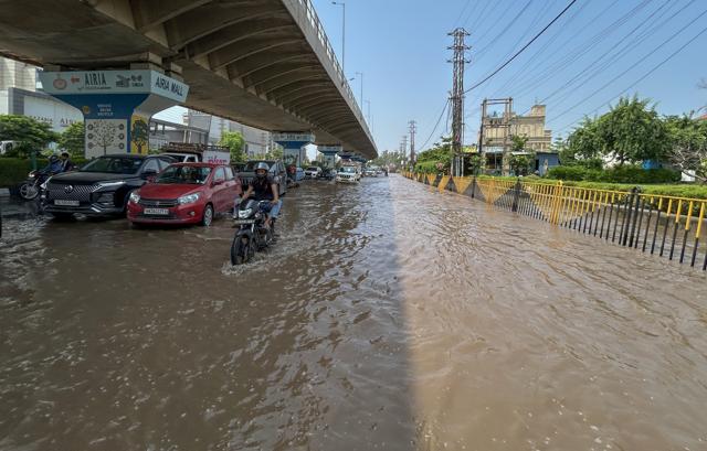 Commuters wade through a waterlogged stretch on Gurugram-Sohna Road near Airia Mall on Saturday. (Parveen Kumar/HT) Commuters wade through a waterlogged stretch on Gurugram-Sohna Road near Airia Mall on Saturday. (Parveen Kumar/HT)