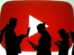 FILE PHOTO: Silhouettes of laptop and mobile device users are seen next to a screen projection of the YouTube logo in this picture illustration taken March 28, 2018.  REUTERS/Dado Ruvic/Illustration/File Photo
