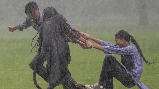 Students play near Kartavya Path amid monsoon showers, in New Delhi, Monday, Aug. 24, 2026. The weather office issued a red alert for heavy rain and a yellow alert for moderate rain across several districts, with thunderstorms, lightning and winds of 30-40 kmph also expected in parts of the city.