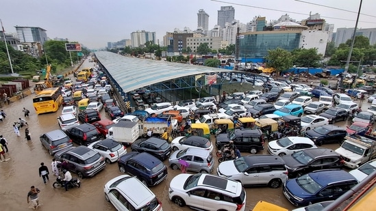 Vehicles remain stuck in a traffic jam on a waterlogged road following heavy rainfall, in Gurugram, Haryana, Monday