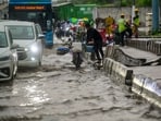 Traffic moves slowly through a waterlogged stretch on Ghazipur Road during heavy monsoon rain in New Delhi.