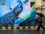 Gram it: Carrying a black umbrella, as this woman travels in the city, what captures the lensman's eye is the vibrant mural beside her. Depicting a peacock, amid heavy rainfall in Delhi, this wall art truly stands out! For today, the IMD has issued a forecast for generally cloudy sky with possibility of very light to light rain. (Photo: Manan VATSYAYANA / AFP)