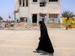 A woman walks past the building of the destroyed Shajareh Tayebeh primary school in Minab in Iran. 