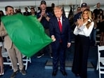 U.S. President Donald Trump waves the green flag to start the race with first lady Melania Trump at his side, during the Freedom 250 Grand Prix Race on the streets of Washington, D.C.