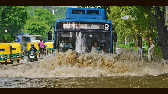 A bus drives through an inundated stretch on Baba Kharak Singh Road on Tuesday. (PTI)