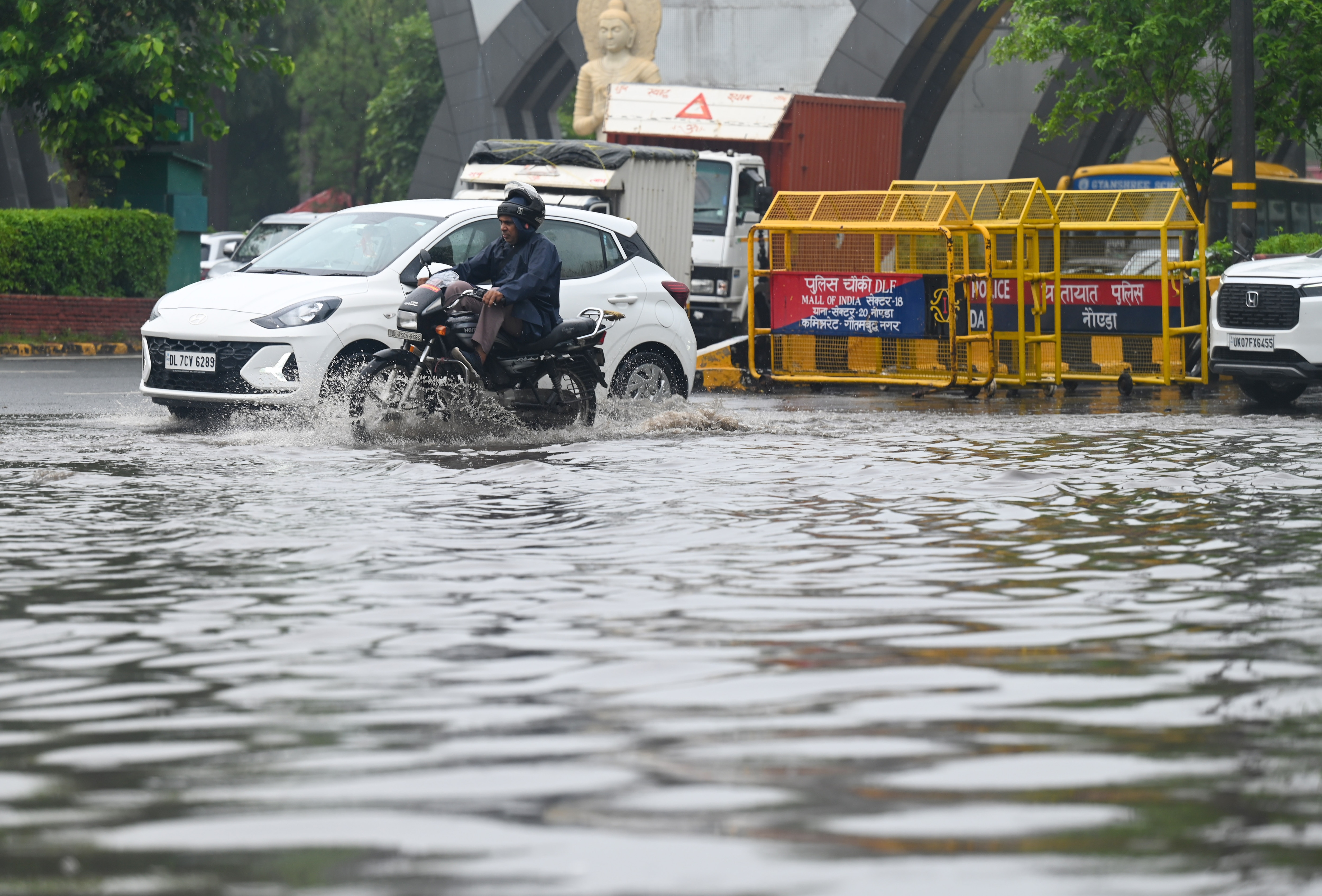 Commuters pass through a waterlogged stretch of road at Noida gate, in Noida. (Sunil Ghosh/HT Photo) Commuters pass through a waterlogged stretch of road at Noida gate, in Noida. (Sunil Ghosh/HT Photo)