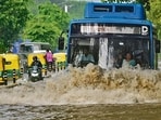 A bus drives through an inundated stretch on Baba Kharak Singh Road on Tuesday. (PTI)