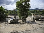 A truck and structures stand partially submerged in a thick layer of mud and debris following flash floods at Beni Ghat area, in Dhading district, Nepal, on Wednesday. (PTI)