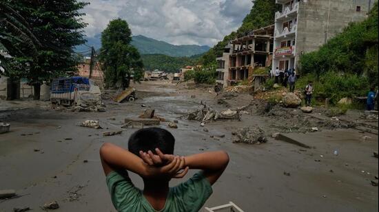 A boy looks at the devastation caused by flash flooding along the Trishuli River in Nepal's Nuwakot district, Wednesday, Aug. 26, 2026. (AP Photo/Niranjan Shrestha)