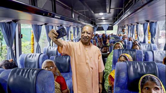 Chief minister Yogi Adityanath takes a selfie during the launch of the ‘Lokmata Ahilyabai Matrushakti Yatra’ scheme, in Lucknow on Wednesday. (PTI PHOTO)