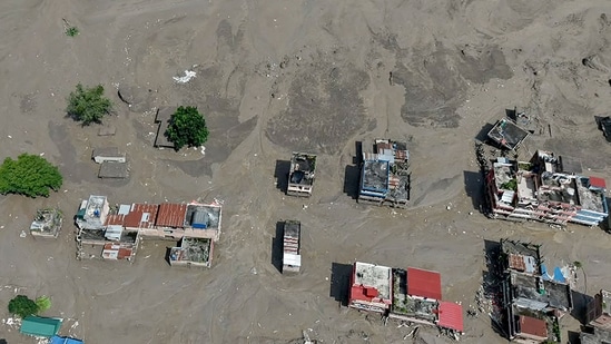 Houses lie partially submerged in muddy water along a riverside after flash floods at Trishuli Bazar in Nepal's Nuwakot district on August 26, 2026.