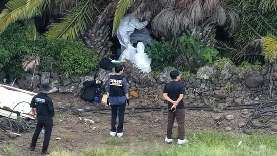 Police officers inspect the scene where the body of missing person Jang Mi-ran was discovered at a palm tree farm in Jeju on the Jeju island, South Korea