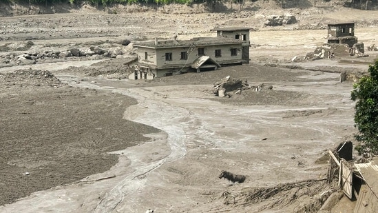 A house lies partially submerged in muddy water after flash floods in Nepal on August 26, 2026.