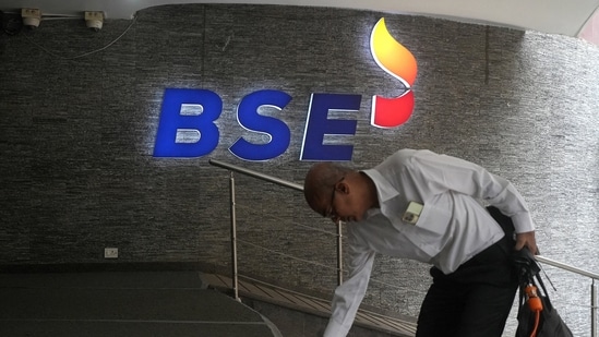 A man touches the stairs as he arrives at the Bombay Stock Exchange (BSE) building in Mumbai