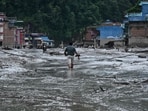 Nepal flash floods LIVE: A resident walks along a street covered in mud following flash floods and a landslide disaster in Devghat, in Nepal's Nuwakot district.(AFP)