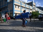 Residents leave after receiving utility aid at a hospital turned temporary shelter after flash floods in the Devighat area of Nepal's Nuwakot district on August 27, 2026. 