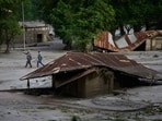 People walk amid damage in the aftermath of flash floods in Devighat in the Nuwakot district in Nepal.
