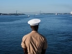 A member of the U.S. Marine Corps looks at the sea from aboard the Wasp-class amphibious assault ship USS Kearsarge Navy ahead of the Sail 250 parade of ships in New York Harbor,(Reuters)