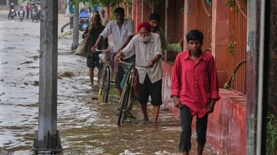 Pedestrians are seen wading though a flooded road after Yamuna overflowed in Delhi following heavy rain. (Manish Swarup/AP) Pedestrians are seen wading though a flooded road after Yamuna overflowed in Delhi following heavy rain. (Manish Swarup/AP)