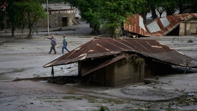 People walk amid damage in the aftermath of flash floods in Devighat in the Nuwakot district in Nepal. (AP) People walk amid damage in the aftermath of flash floods in Devighat in the Nuwakot district in Nepal. (AP)
