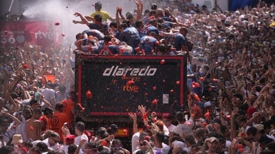 Revellers cheer as people from a truck throw tomatoes at the La Tomatina festival-goers. (AP Photo/Alberto Saiz) Revellers cheer as people from a truck throw tomatoes at the La Tomatina festival-goers. (AP Photo/Alberto Saiz)