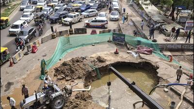 Two service lanes remain barricaded after a sewer drain collapse created a large sinkhole, triggering congestion and panic among commuters. (PTI)