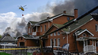 A damaged house as a firefighting helicopter carries a load of water to extinguish a fire at a warehouse following an air attack near Boryspil, Kyiv region on August 27, 2026, amid the Russian invasion of Ukraine. (AFP) A damaged house as a firefighting helicopter carries a load of water to extinguish a fire at a warehouse following an air attack near Boryspil, Kyiv region on August 27, 2026, amid the Russian invasion of Ukraine. (AFP)