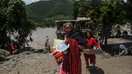 Women carry belongings from their damaged homes after a flash flood and a mudslide, in Galchhi, Nepal, August 27, 2026.(REUTERS)