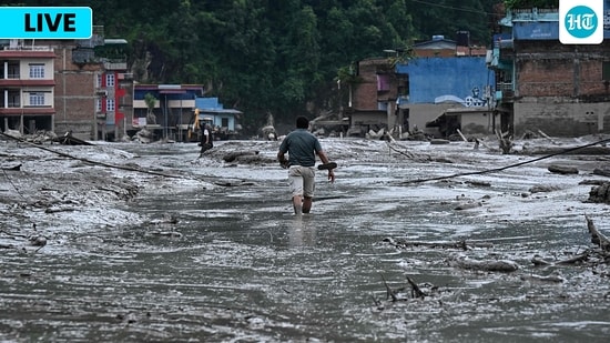 Nepal flash floods LIVE: A resident walks along a street covered in mud following flash floods and a landslide disaster in Devghat, in Nepal's Nuwakot district.