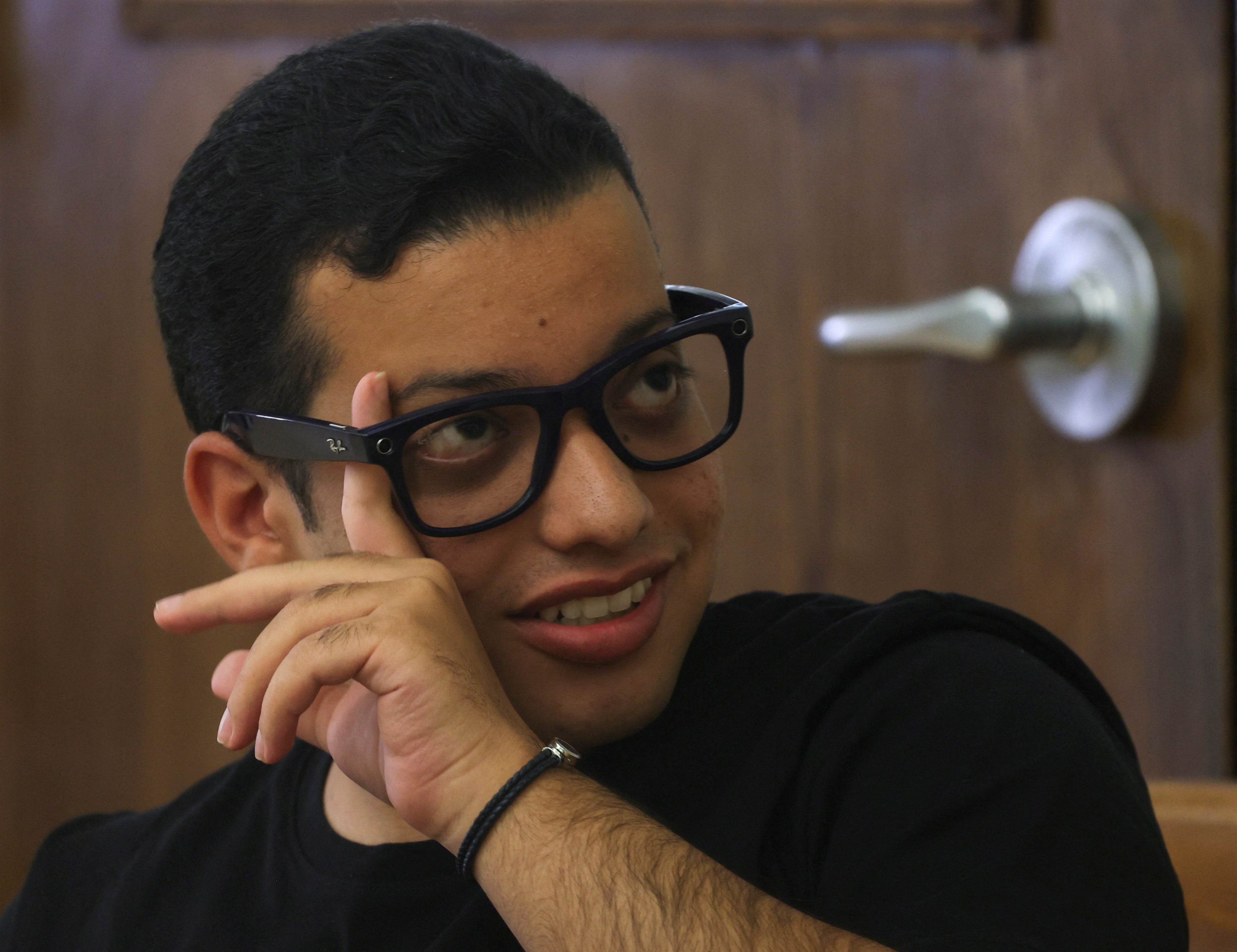 Mark Morad, 20, a visually impaired Egyptian student, entrepreneur and developer of the AI-powered Scribeme application, wears Meta smart glasses while using the application at the American University in Cairo (AUC), Egypt, August 12, 2026. (REUTERS)