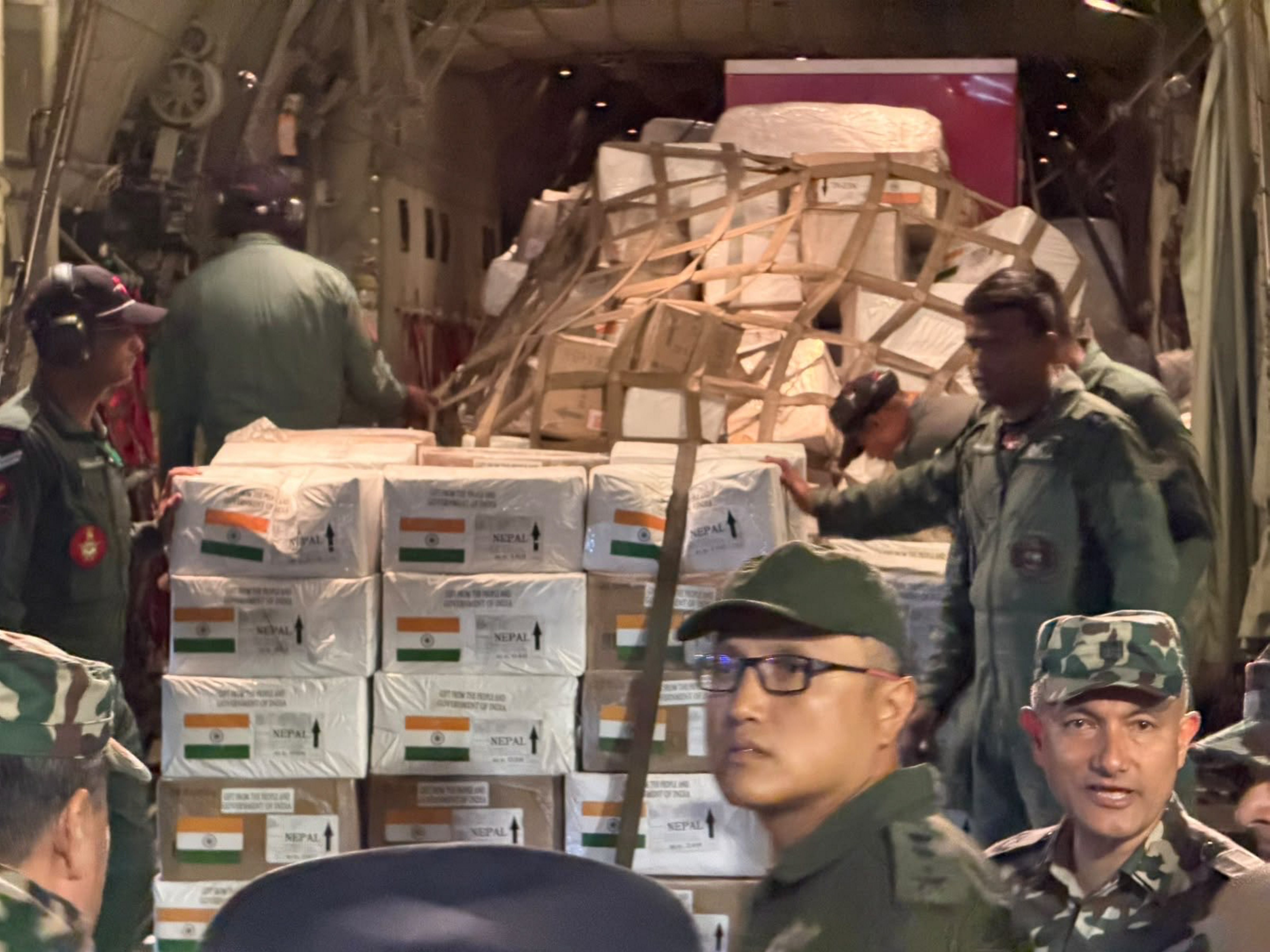 Personnel unload boxes of emergency relief material from an Indian Air Force aircraft following its arrival in Kathmandu. India dispatched a 10-tonne humanitarian assistance package containing essential supplies to support immediate post-disaster search, rescue, and rehabilitation efforts following severe floods in Nepal. (@MEAIndia/X)