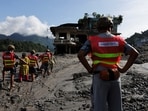Rescuer help women to move through a muddy road following flash floods and a mudslide in Trishuli,, Nepal, August 28.(REUTERS)