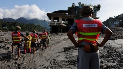 Rescuer help women to move through a muddy road following flash floods and a mudslide in Trishuli,, Nepal, August 28. (REUTERS)