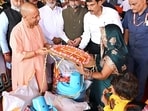 Chief minister Yogi Adityanath interacts with a woman during the relief material distribution programme for the flood-affected families of the Bansdih and Ballia Sadar areas, in Ballia on Saturday. (Sourced)