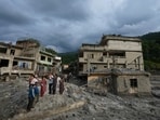 Residents and others look at damaged structures after flash flooding in the Devighat area of the Nuwakot district in Nepal.