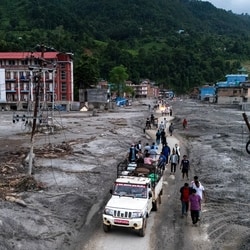 A drone view of people walking on a road and houses in mud, following deadly flash floods and mudslides at Devighat, Nuwakot district, Nepal, (Photo for representation)