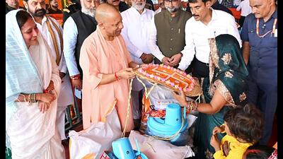 Chief minister Yogi Adityanath interacts with a woman during the relief material distribution programme for the flood-affected families of the Bansdih and Ballia Sadar areas, in Ballia on Saturday. (Sourced)