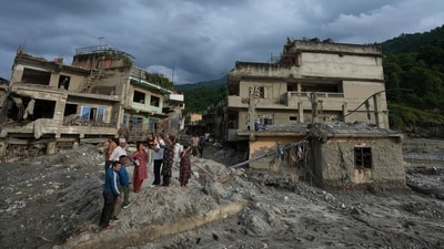 Residents and others look at damaged structures after flash flooding in the Devighat area of the Nuwakot district in Nepal. (AP)