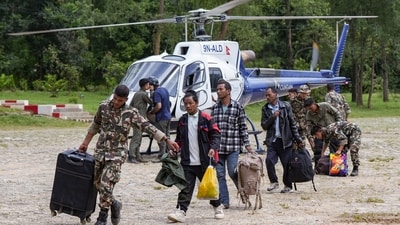 Army personnel assist people as they disembark from a rescue helicopter at an army camp in Trishuli, Nuwakot district, Nepal. (PTI)