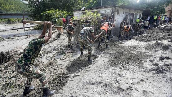 Dhading: Army personnel shovel thick mud and debris to clear houses inundated by severe flash floods, in Dhading district, Nepal. (PTI)