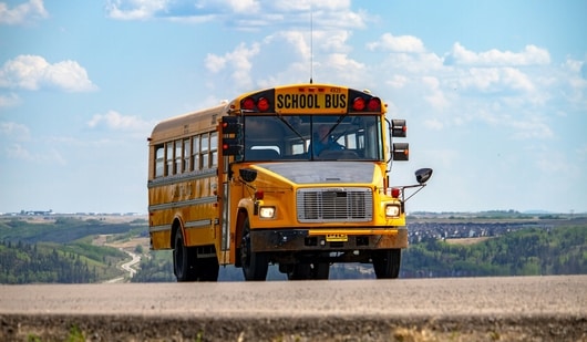 Yellow school buses were chosen for their visibility and contrast with black lettering, enhancing safety for child transportation.
