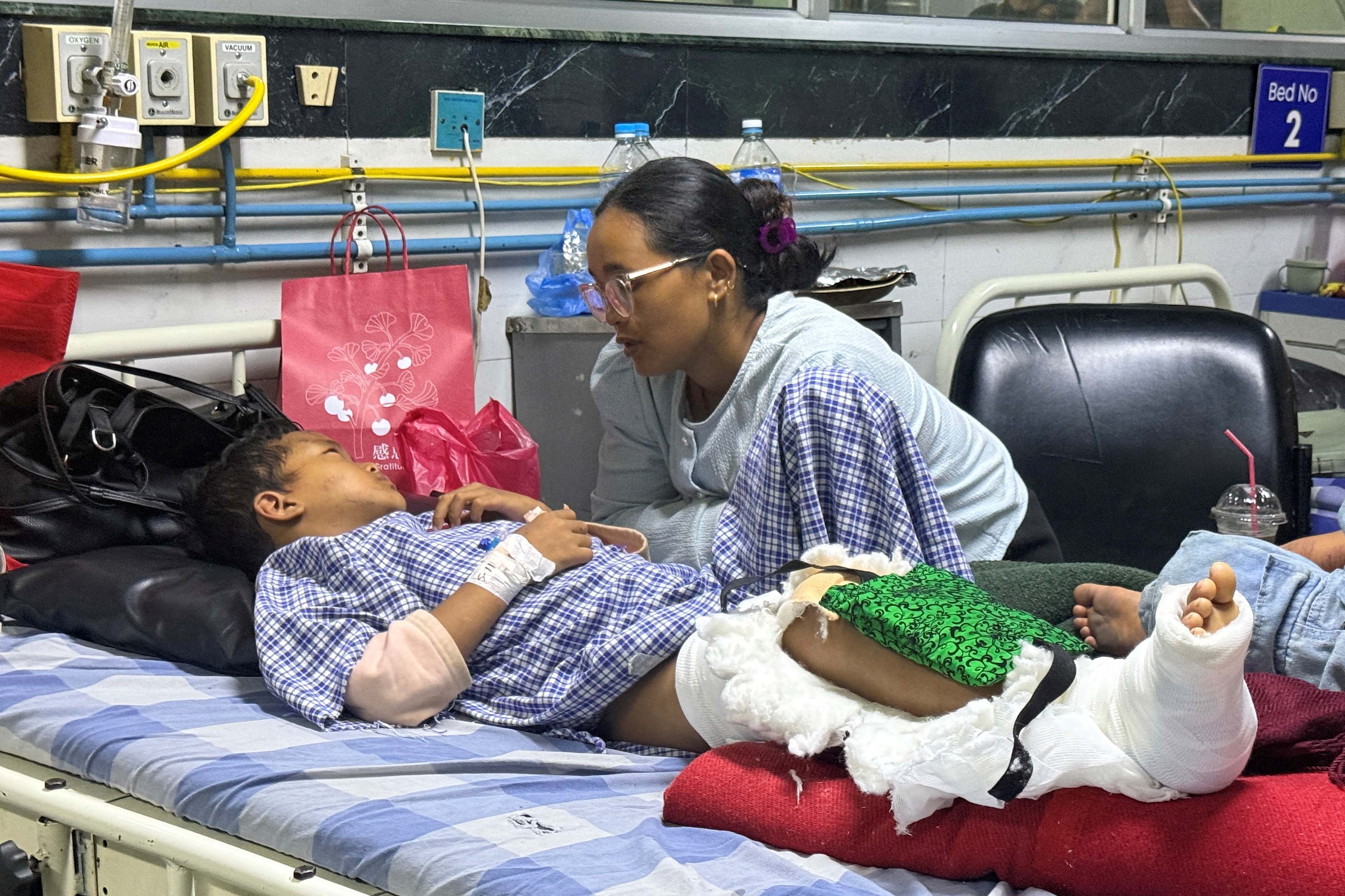 Matti Maya Tamang, 28, speaks with her son Zoyal Ghale, 8, who was airlifted from Rasuwa after being injured in the deadly flash floods, inside a hospital in Kathmandu, Nepal. (REUTERS)