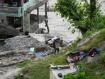 A man carries essentials in the aftermath of flash floods, at Trishuli market, in Nuwakot district, Sunday,(PTI)