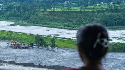 Nuwakot: People sit near a damaged structure as they look on the flood-ravaged Trishuli river in the aftermath of flash floods, at Trishuli market, in Nuwakot district, Sunday, Aug. 30, 2026. (Representative Image/PTI)