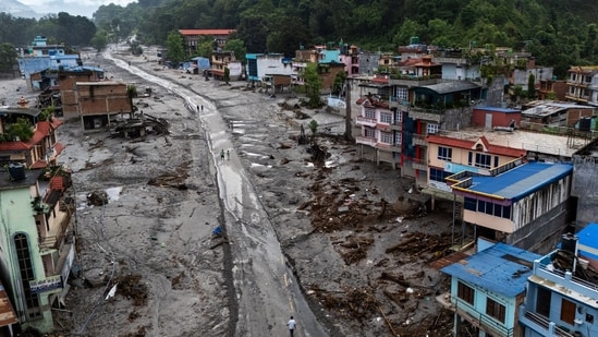 Nepal flash floods live updates: A drone view shows people walk on a road and houses covered in mud following deadly flash floods and mudslides, in Devighat, Nuwakot district, Nepal.