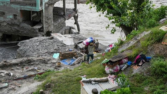 A man carries essentials in the aftermath of flash floods, at Trishuli market, in Nuwakot district, Sunday,