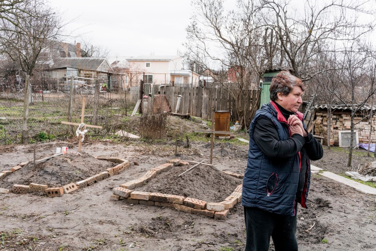 A woman stands next to the graves of people buried during Russia's occupation of Bucha, Ukraine. A woman stands next to the graves of people buried during Russia's occupation of Bucha, Ukraine.