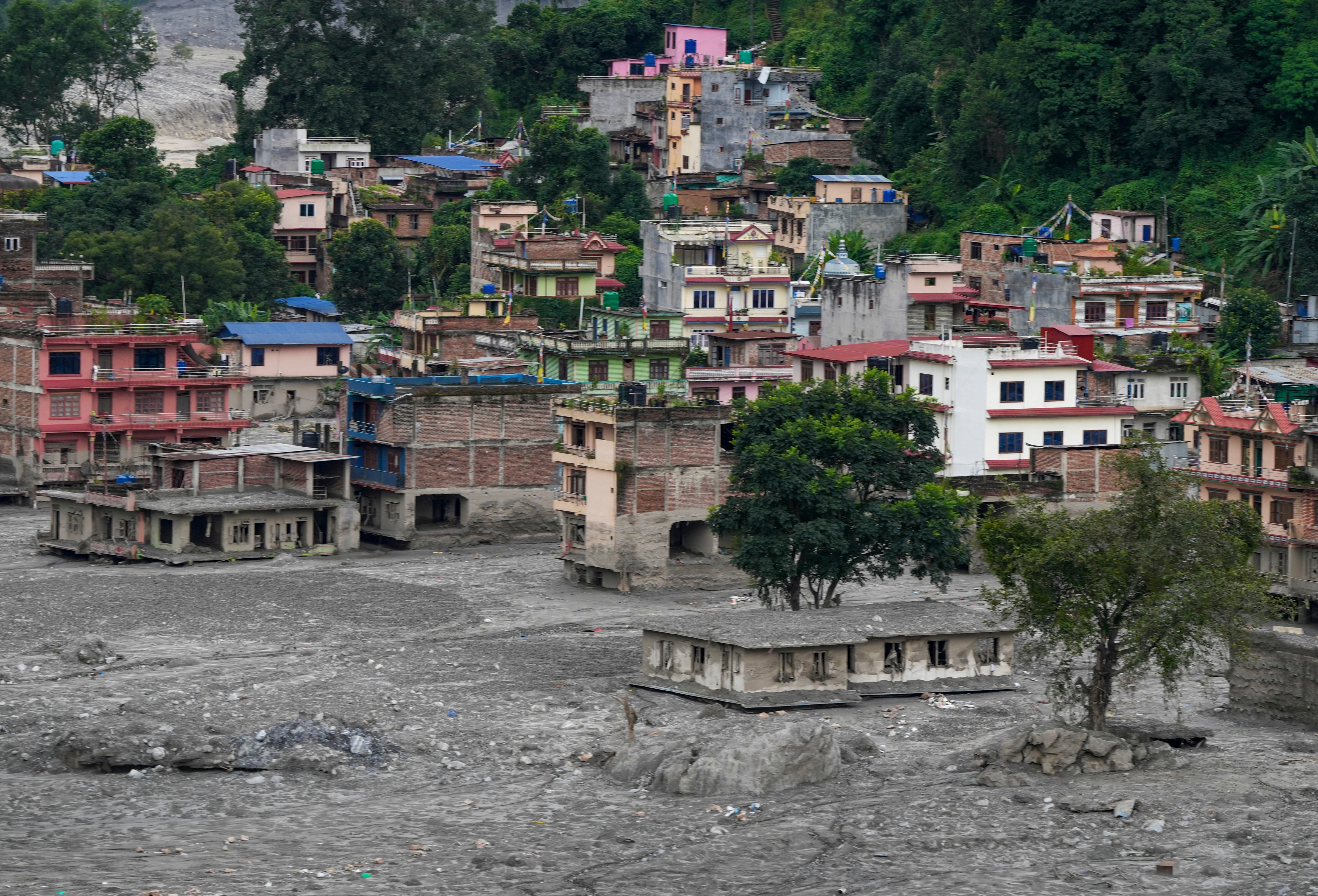 Houses covered in thick mud in the aftermath of flash floods, at Trishuli market, in Nuwakot district, Sunday. PTI Houses covered in thick mud in the aftermath of flash floods, at Trishuli market, in Nuwakot district, Sunday. PTI